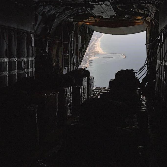 AP reporters aboard a US military plane watch small batches of aid airdropped on a destroyed Gaza